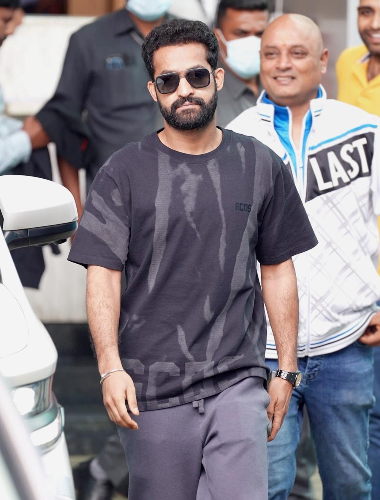Ahead of War 2 release, Jr NTR was seen stepping out of the airport in a loose black T-shirt paired with matching track pants. He flaunted his lean look as he greeted the paparazzi and posed for them before heading to his car.